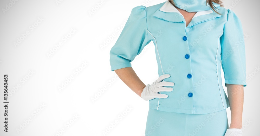 Air hostess in uniform standing with hand on hip