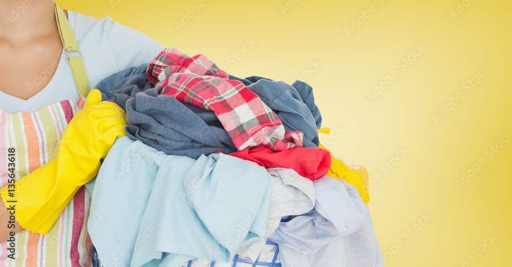 Mid section of woman holding bucket full of clothes