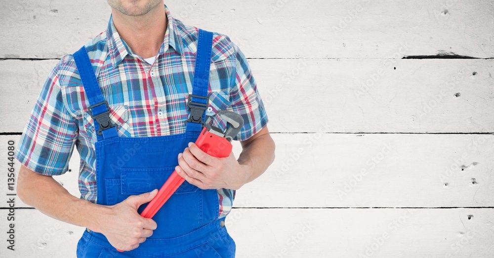 Mid section of handy man holding wrench