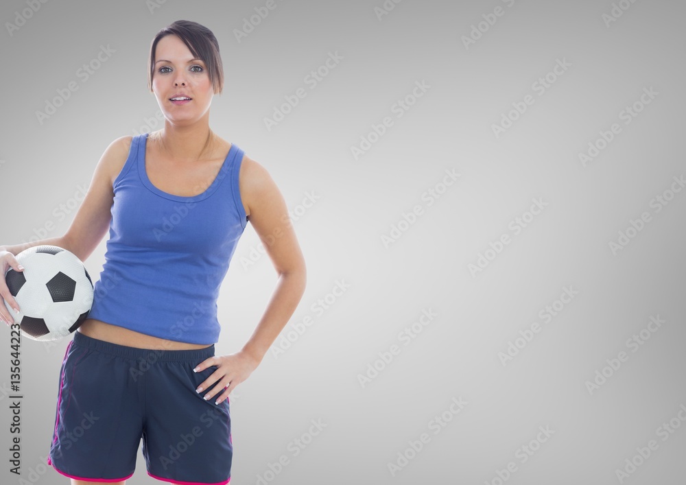 Portrait of fit woman standing with football