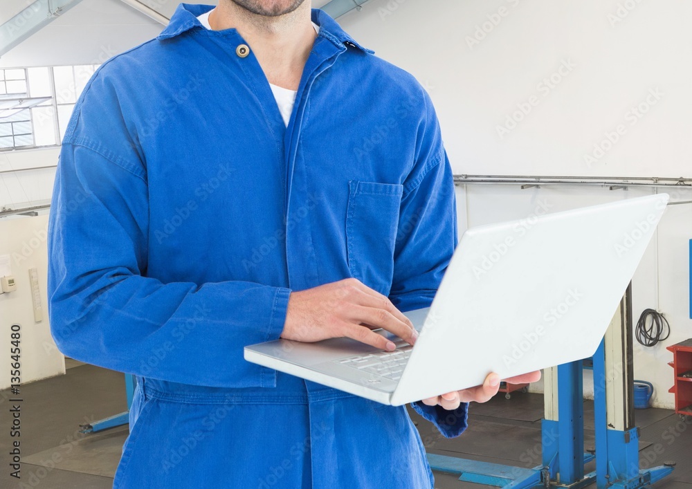 Mechanic using laptop in workshop