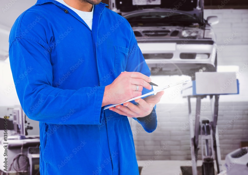 Mid section of mechanic writing on clipboard