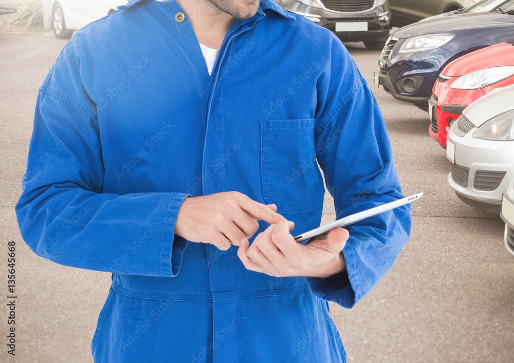 Mid section of mechanic using digital tablet