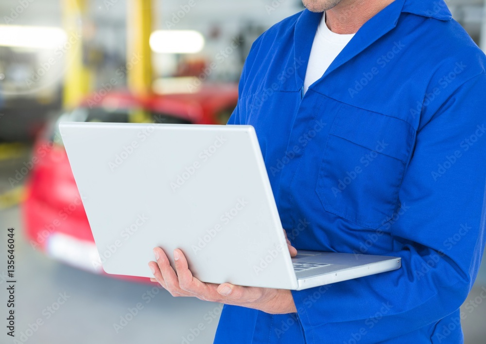 Mechanic using laptop in workshop