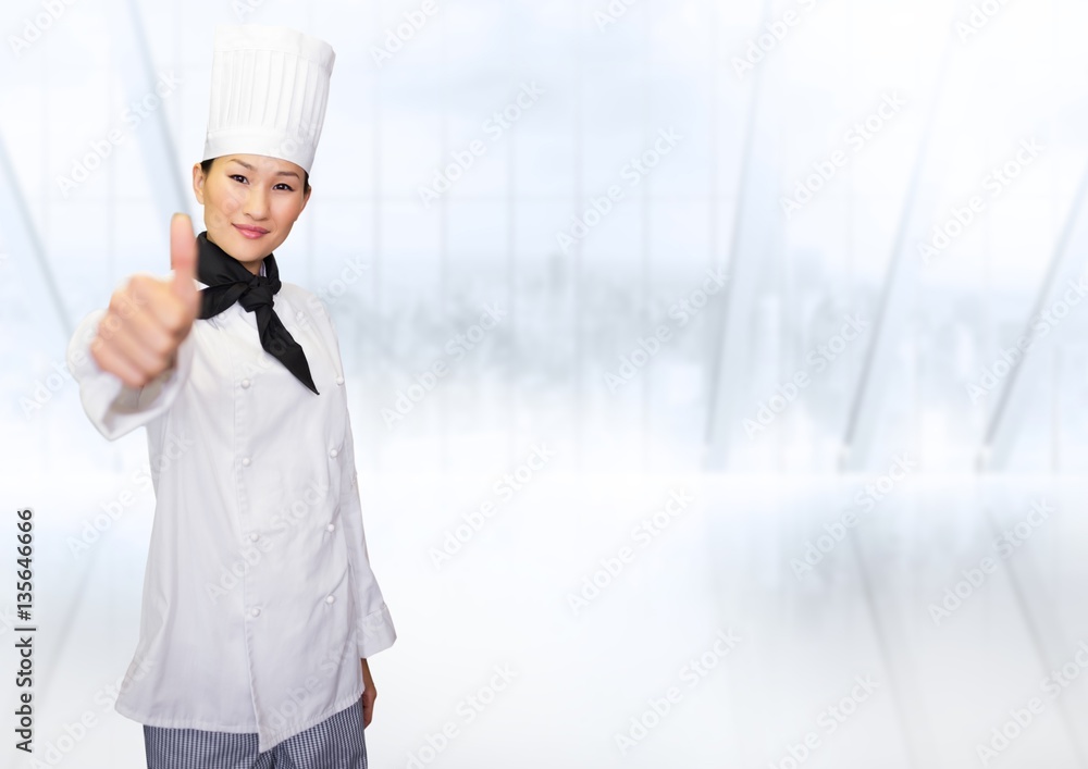 Portrait of smiling female chef cook showing thumbs up