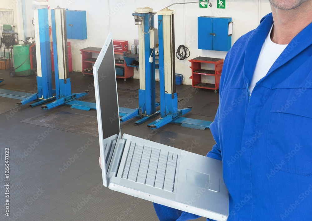 Mechanic using laptop in workshop