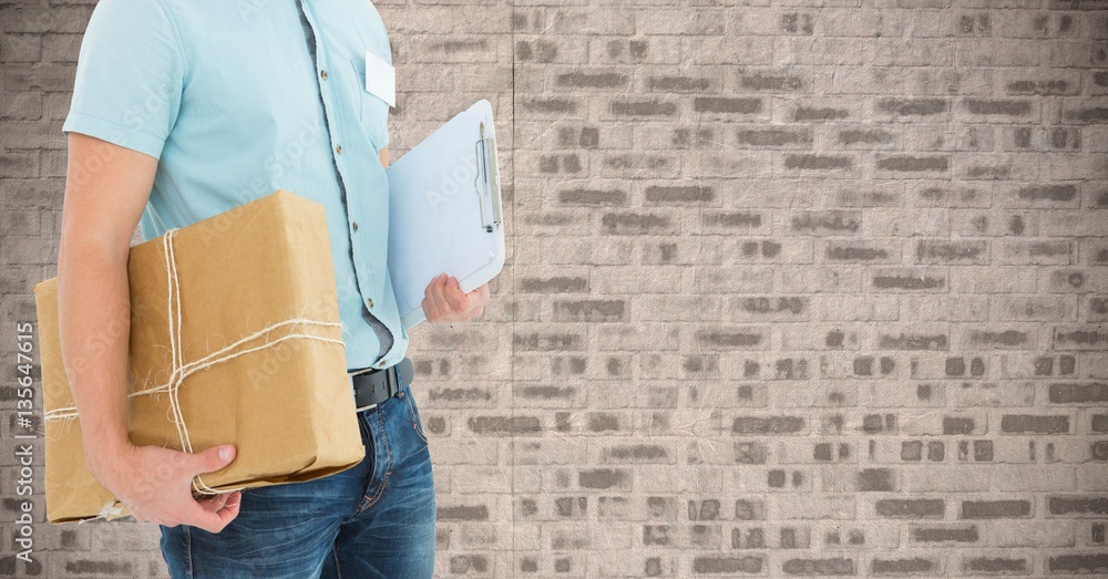 Mid section of delivery man holding parcel box and clipboard