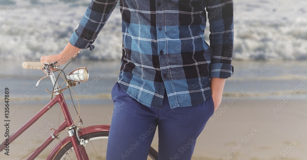 Man standing with bicycle on the beach