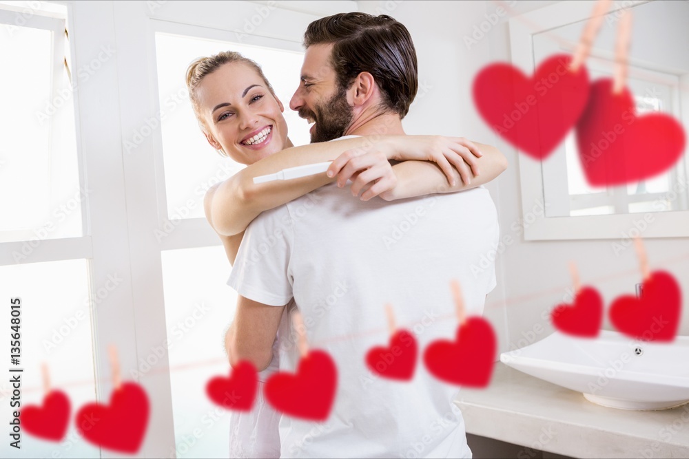 Red hanging heart and couple embracing each other