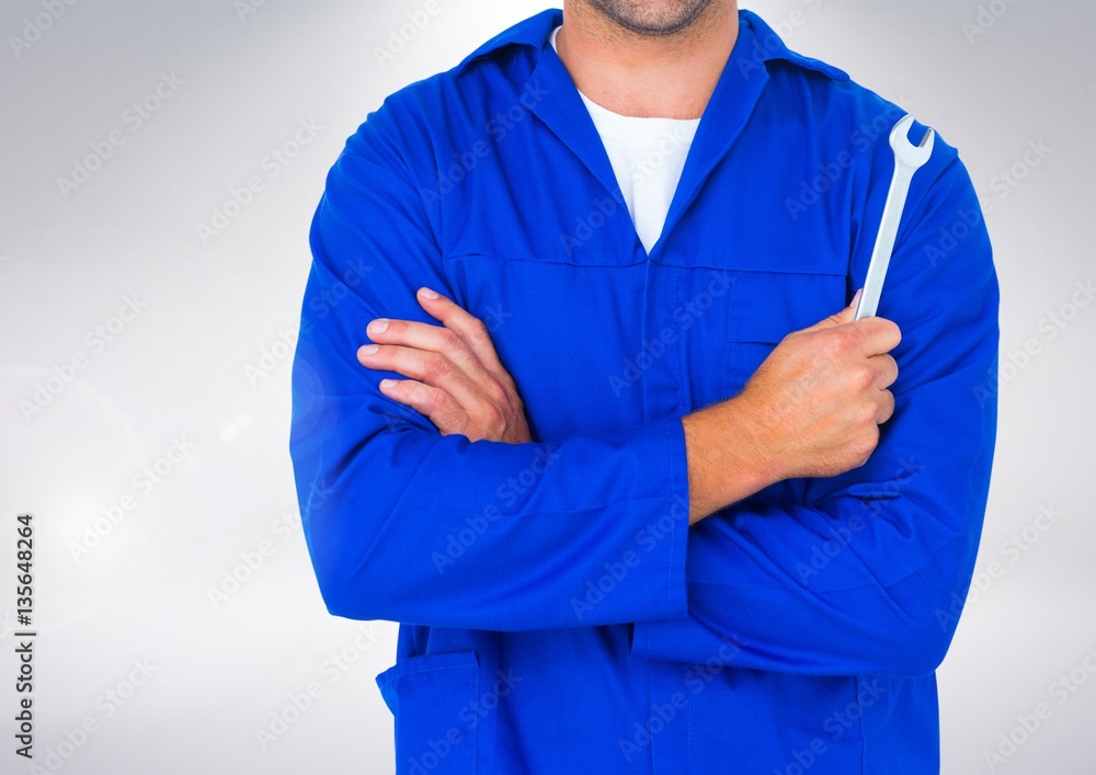 Mid section of mechanic holding a wrench