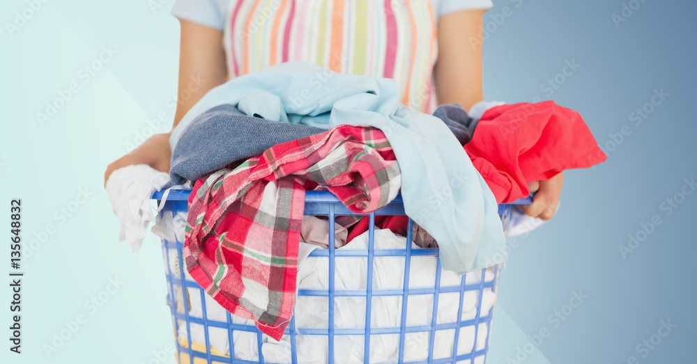 Mid section of female cleaner holding laundry