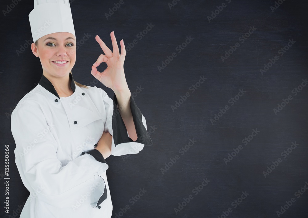 Female chef showing ok against black background