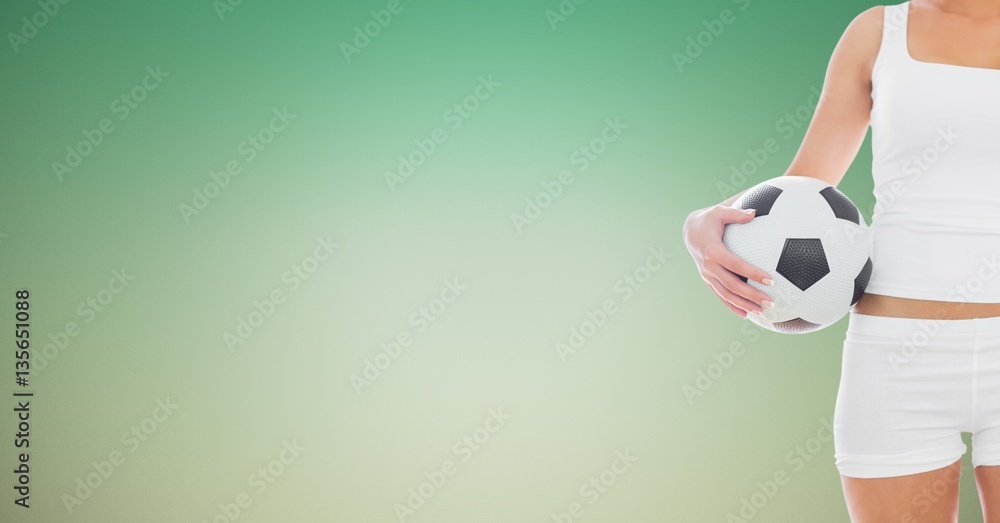 Woman holding football against green background