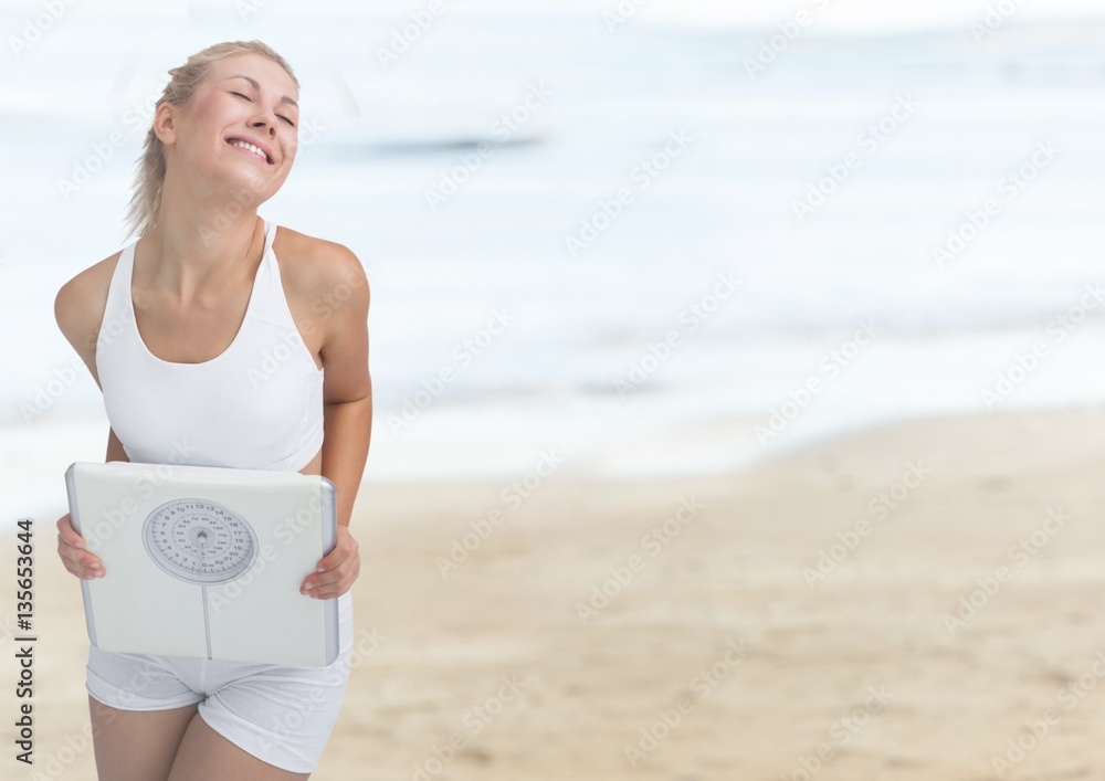 Woman holding weighing scale on the beach