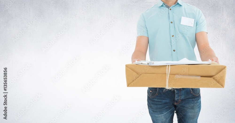 Delivery man holding box against grey background