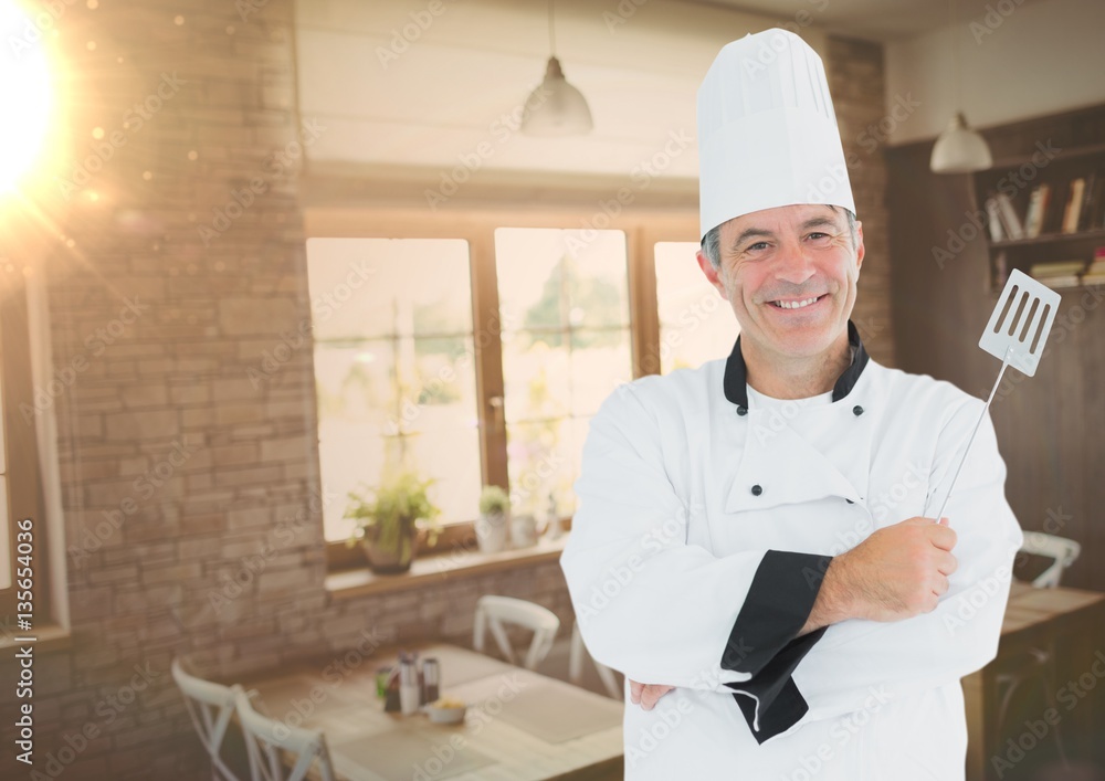 Male chef holding frying spoon in restaurant