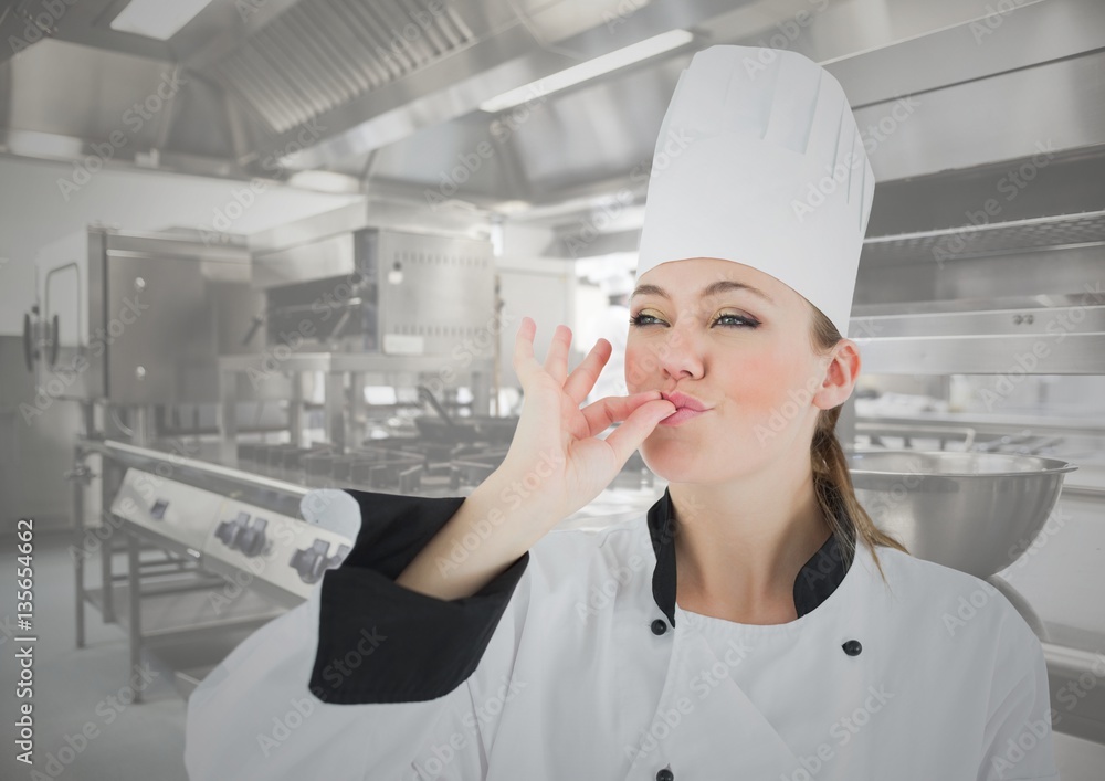 Female chef tasting food in kitchen