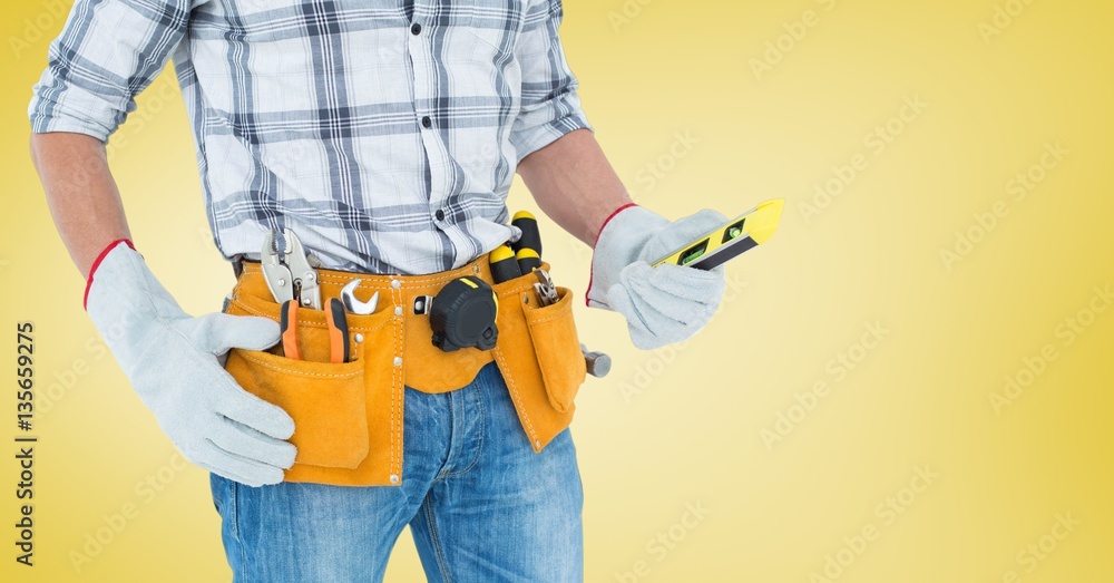 Mid section of handyman with tool belt and spirit level