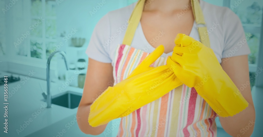 Woman removing rubber gloves in kitchen