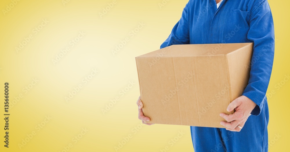 Delivery man holding a box against yellow background