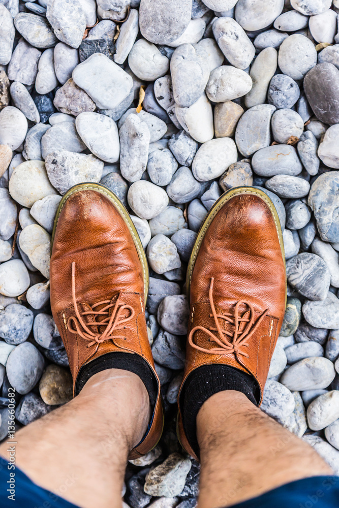 men leather shoe on round pebble stone background