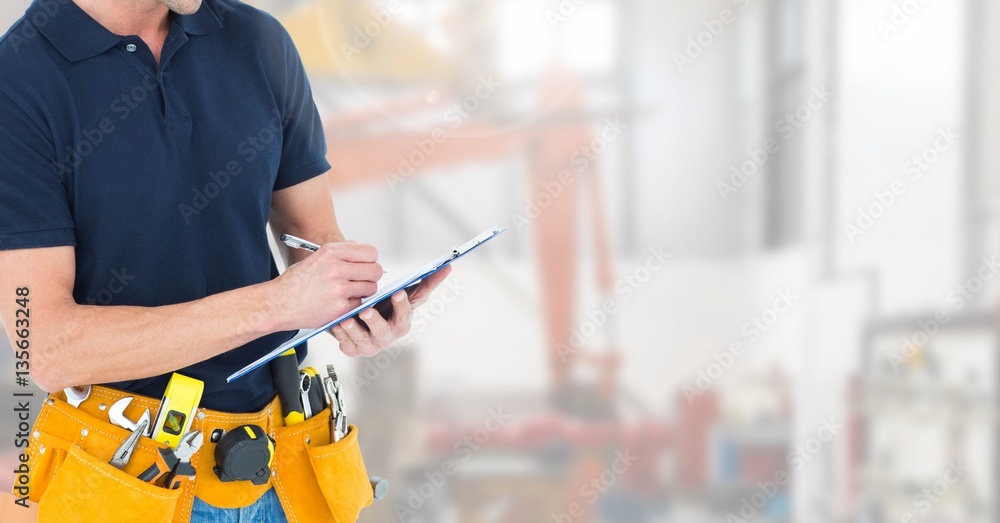 Mid section of construction man writing on clipboard