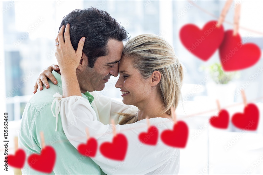 Digitally generated red hearts around romantic couple embracing