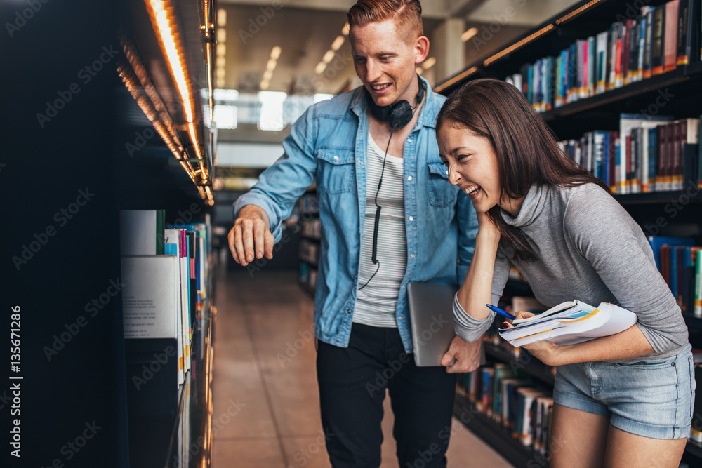 Students at college library looking for books