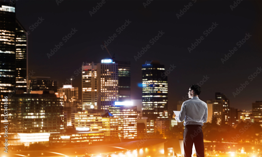 Businessman viewing night glowing city