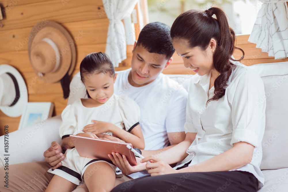 Asian family tablet are playing at home.