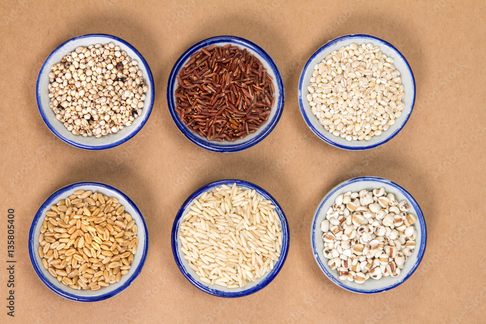 Variety of grain rice in cup on natural brown paper background ;