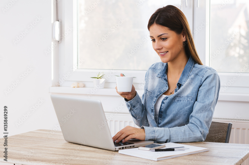 Happy office girl at desk working on laptop