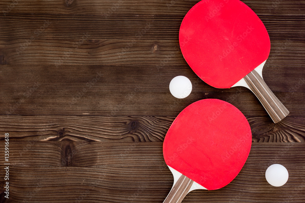 Red racket for ping pong ball wooden background top view