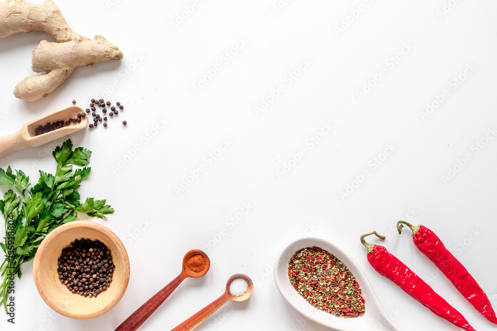 spices in wooden spoon on white background top view