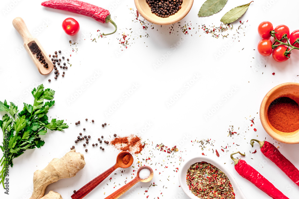 spices in wooden spoon on white background top view