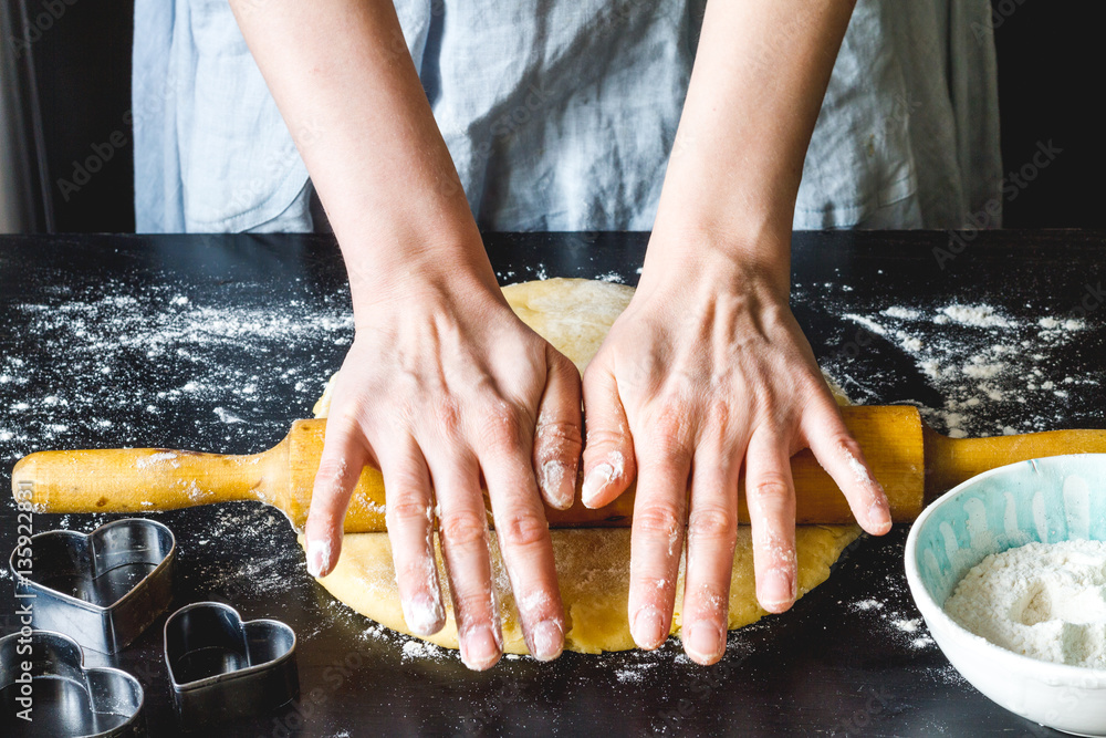 cooking homemade cookies with hands on dark background