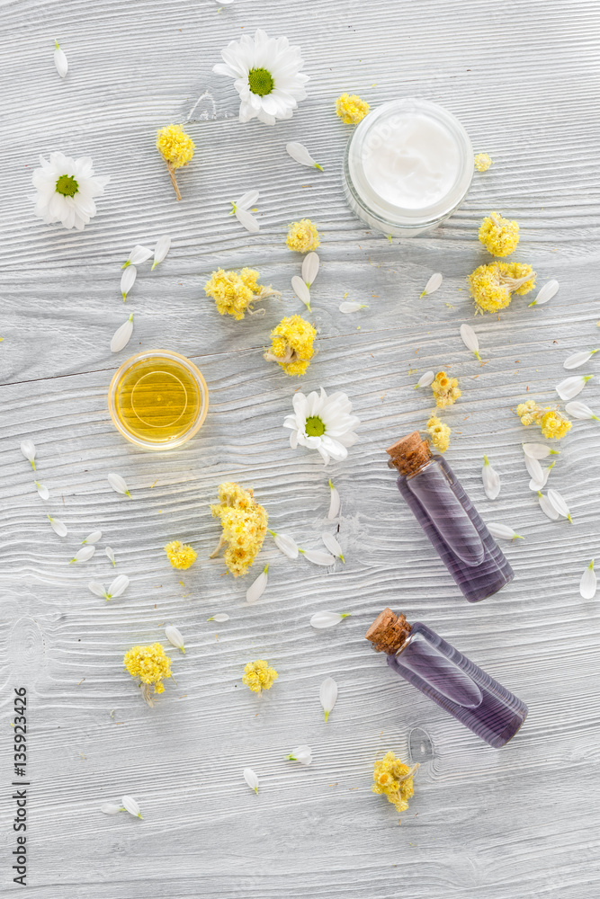 organic cosmetics with camomile on wooden background top view