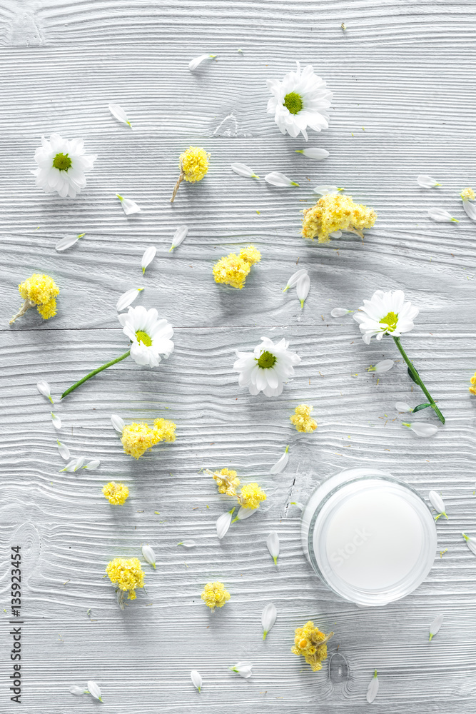 organic cosmetics with camomile on wooden background top view