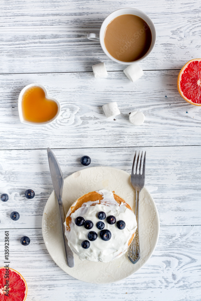 Breakfast concept with flowers on wooden background top view