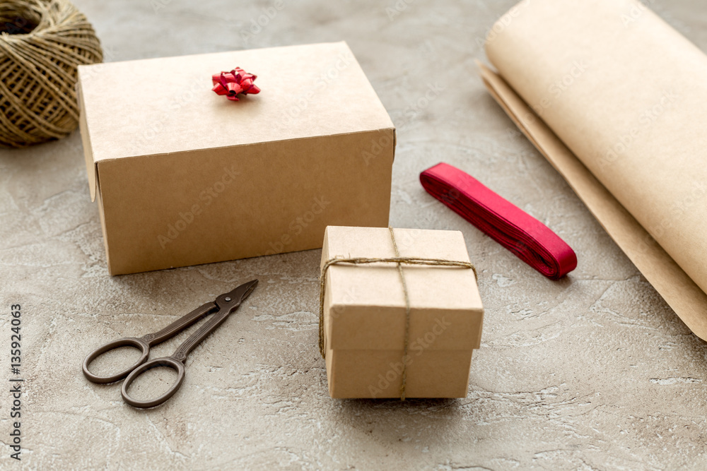 wrapping gifts in box for holiday on stone background