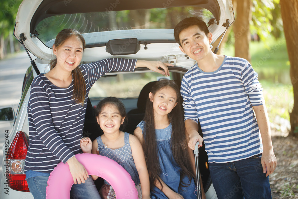 Happy Asian family with mini van are smiling and preparing for travel on summer holiday