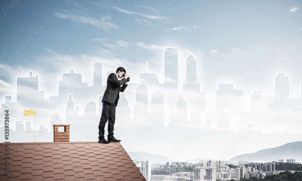 Businessman standing on roof and looking in binoculars. Mixed me