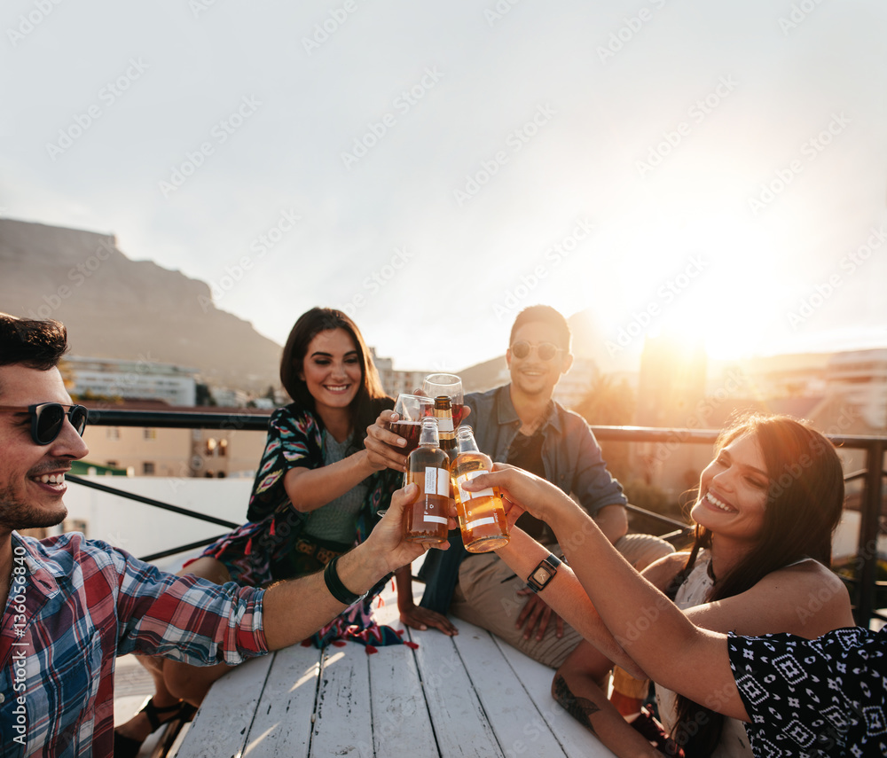 Friends hanging out and enjoying drinks on rooftop party