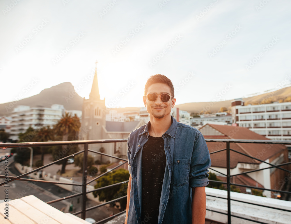 Handsome young man standing on the rooftop