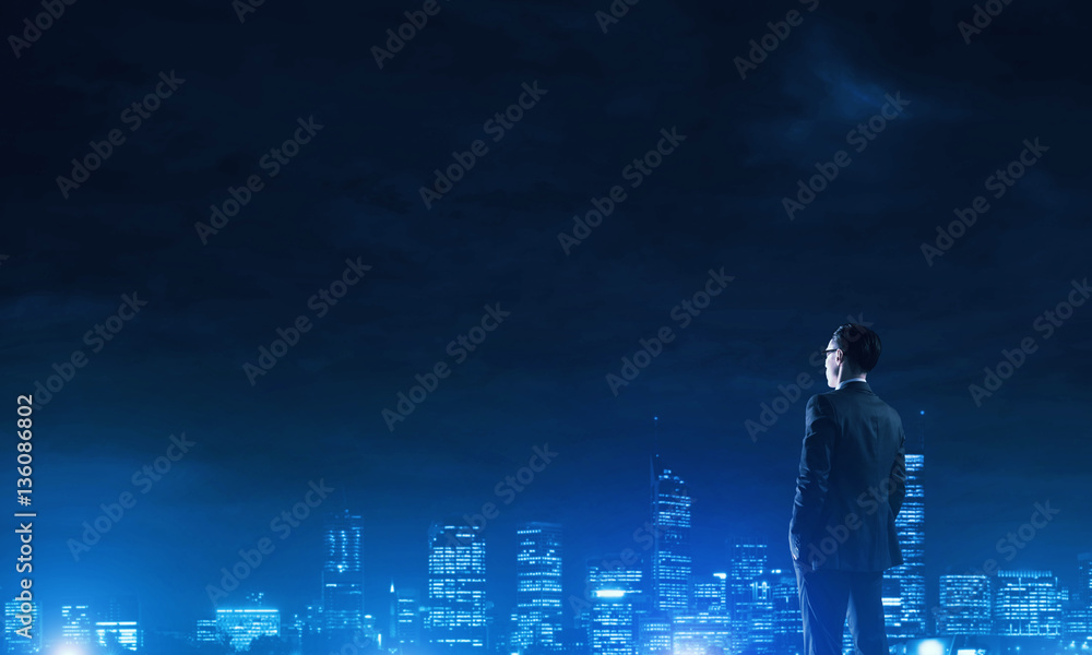 Businessman viewing night glowing city