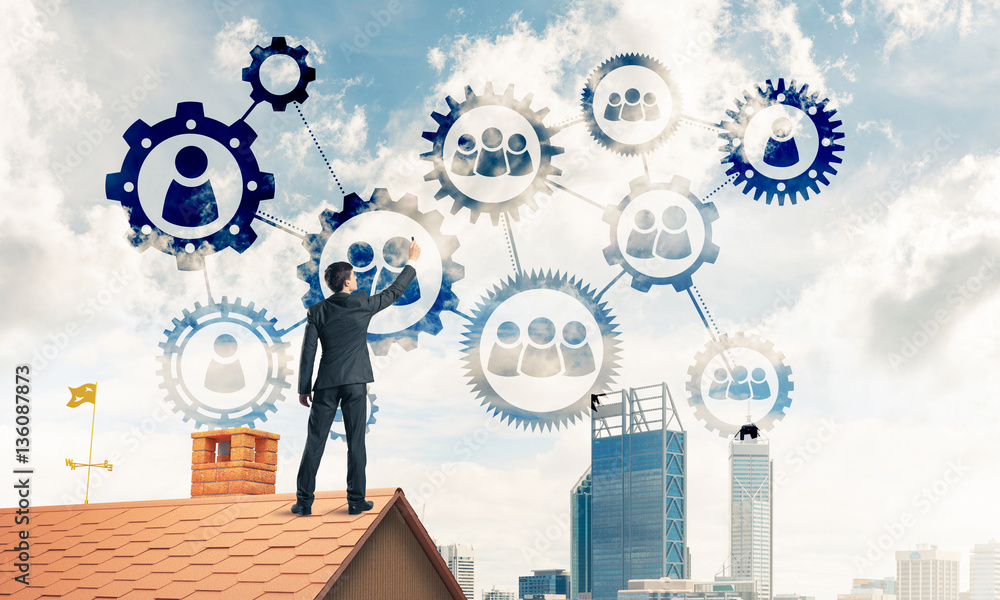 Businessman on house roof presenting teamwork and connection con