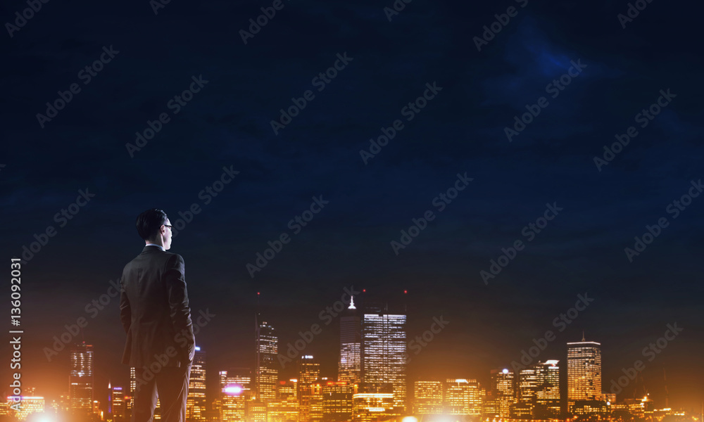 Businessman viewing night glowing city