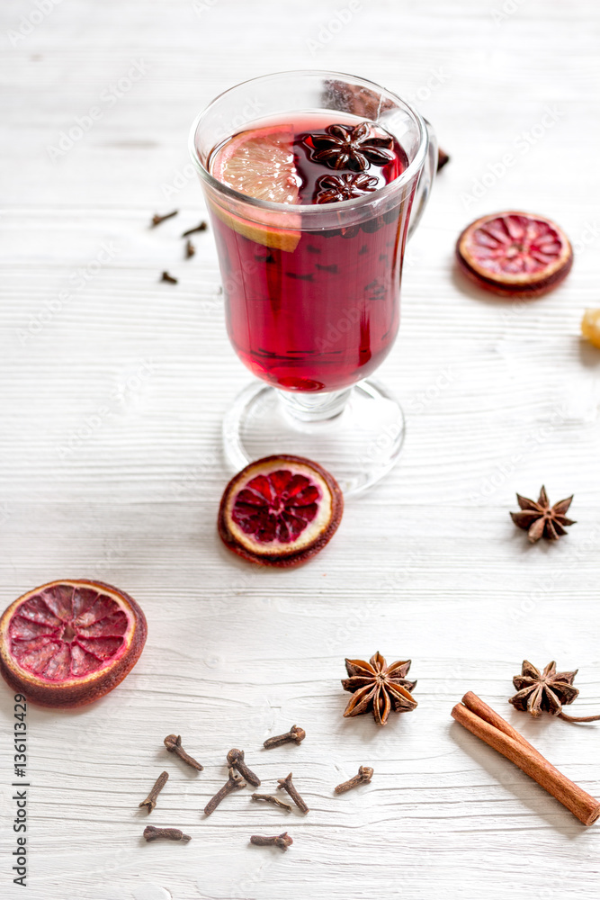 mulled wine with spices in cup on wooden background