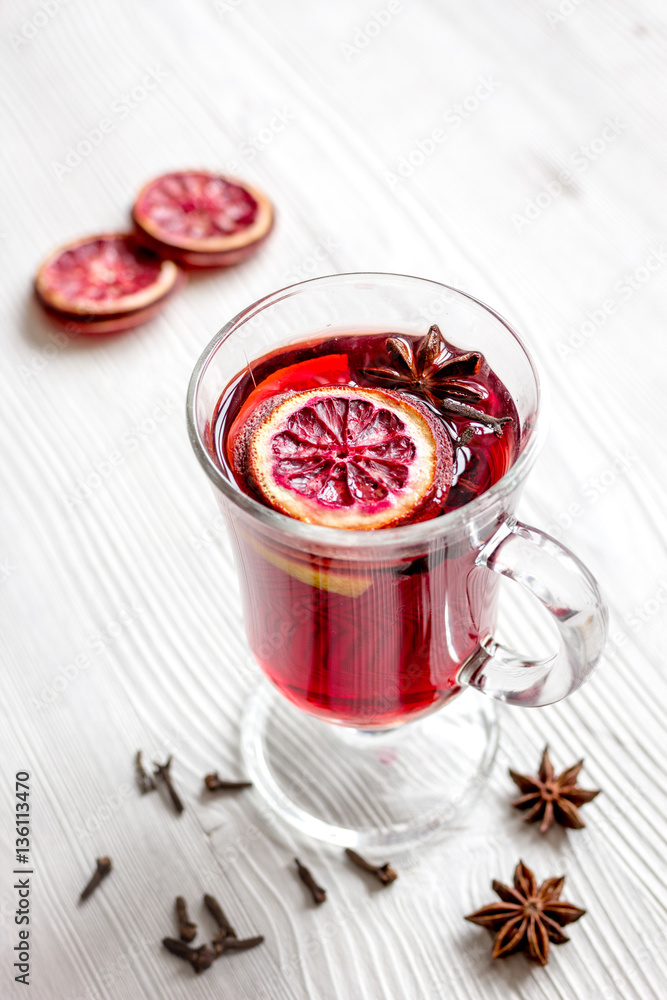 mulled wine with spices in cup on wooden background