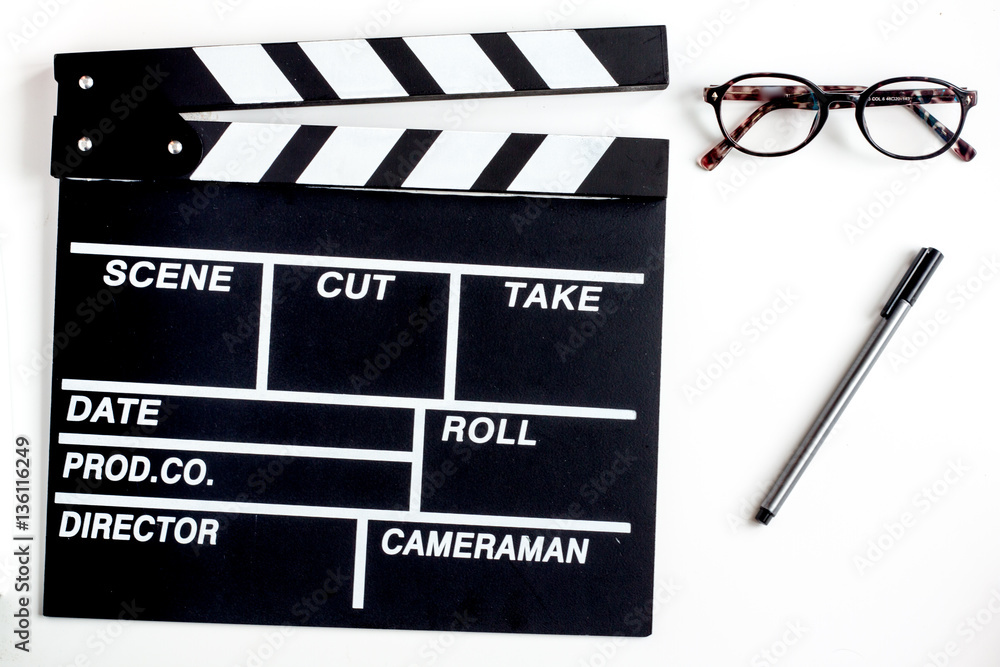 Screenwriter desktop with movie clapper board white background top view